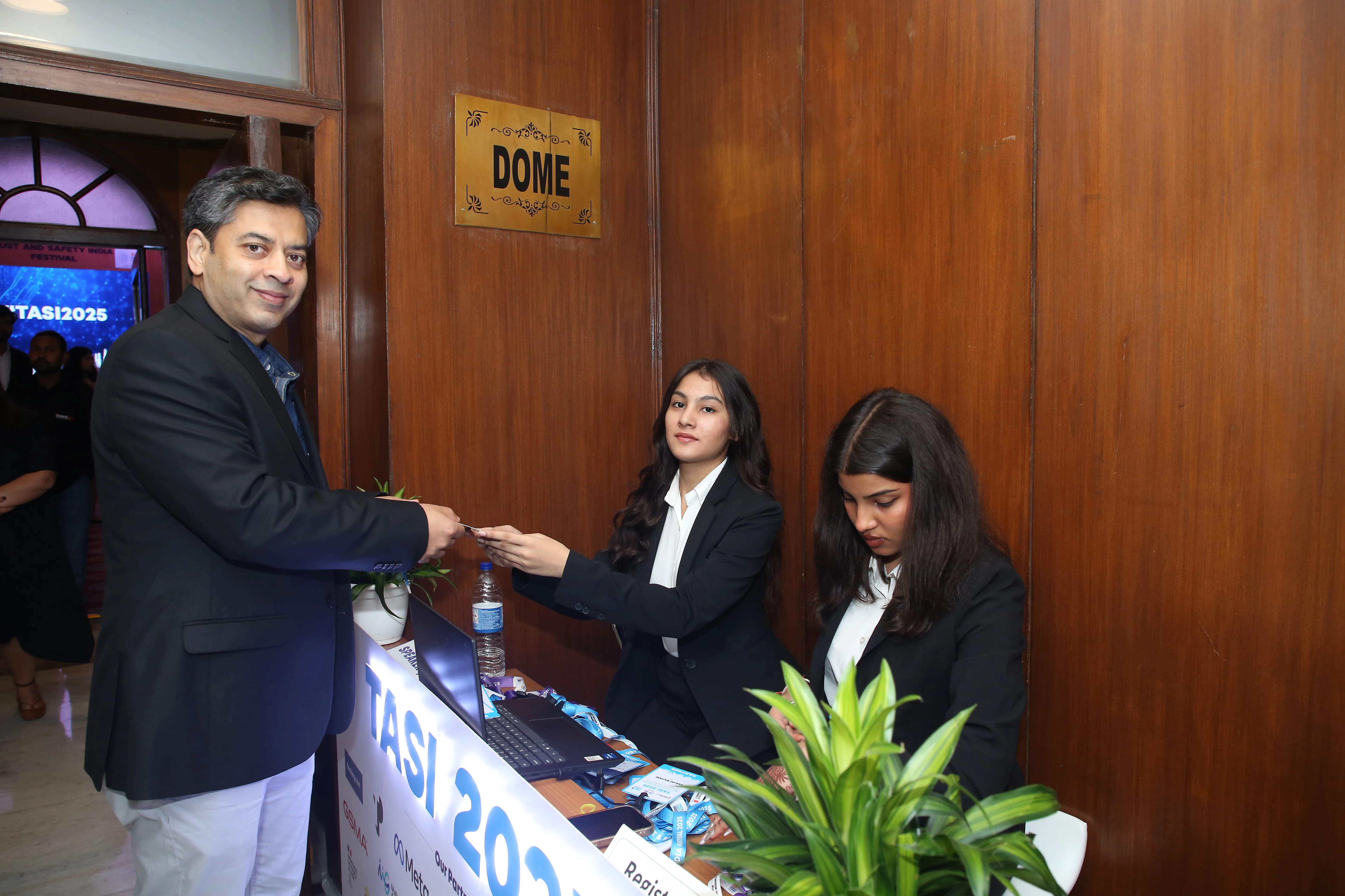 Volunteer team handling attendee check-in and badge handoff at TASI