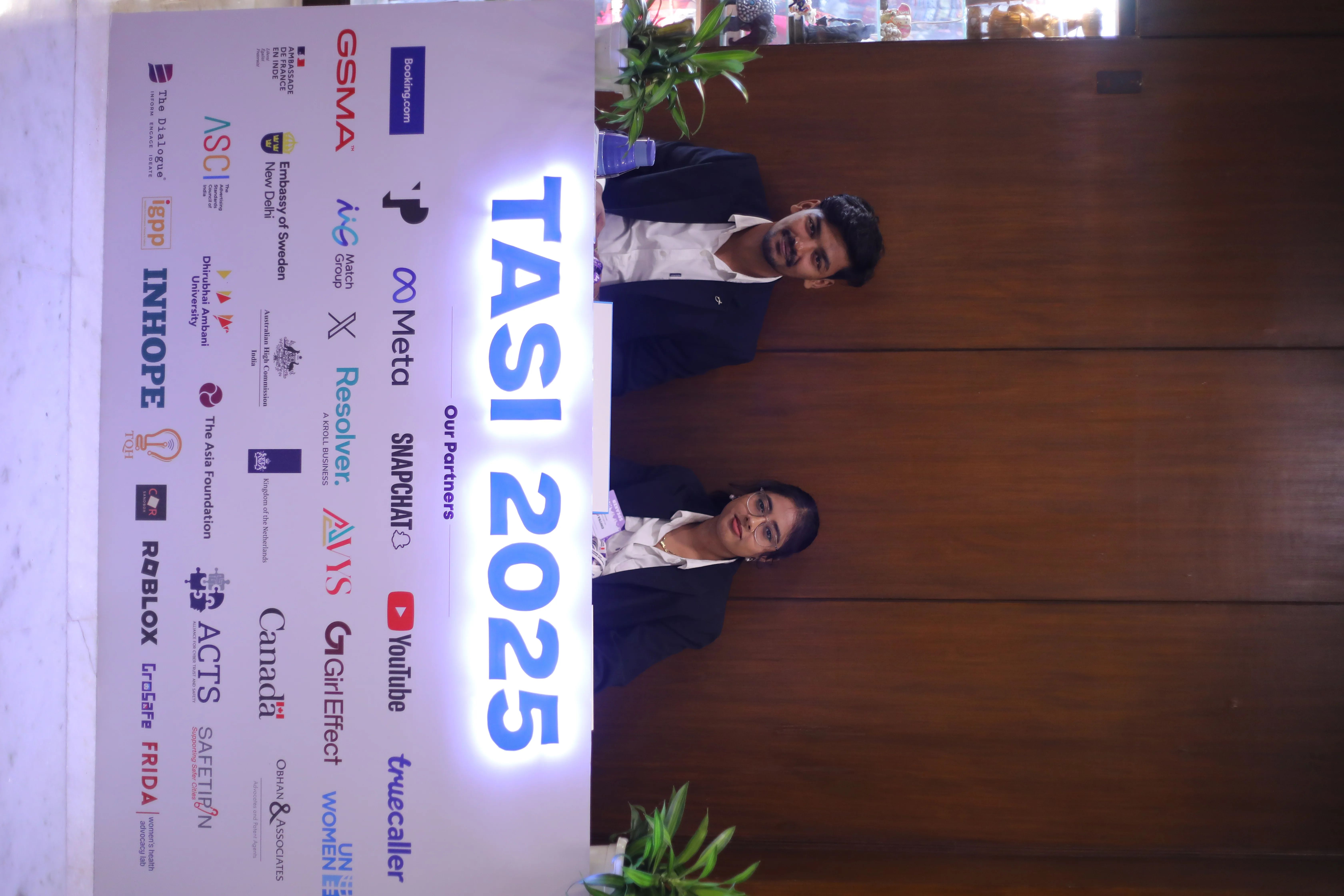 Volunteer team members standing behind a TASI partner display